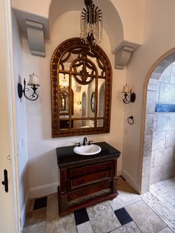 Two ornate antique-style arched wall mirro