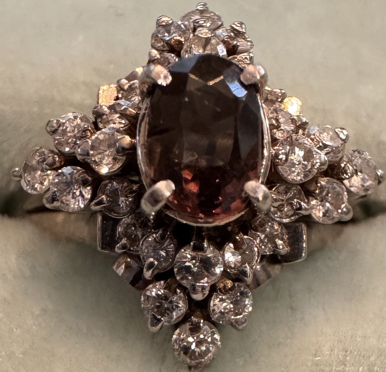 platinum ring with an oval -cut alexandrite center stone accented by round brilliant diamonds.