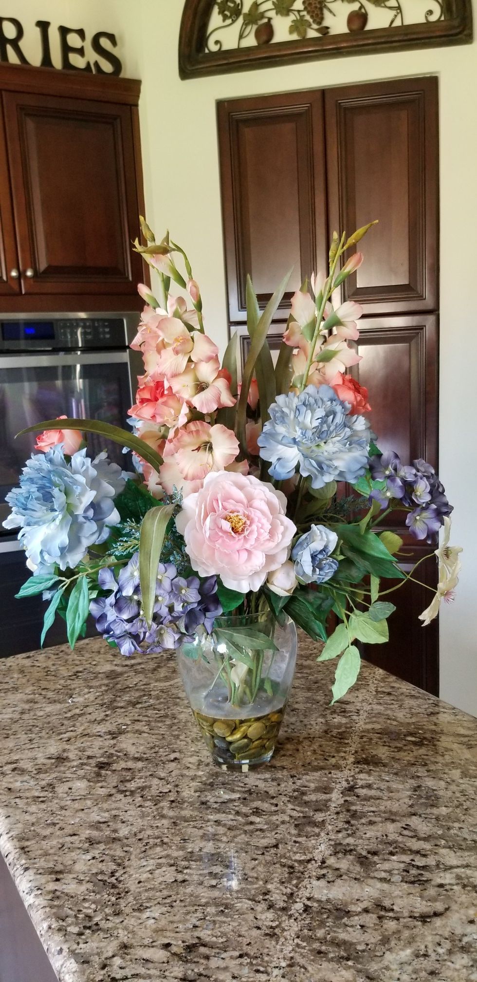 Flower arrangement in glass vase with stones