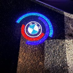 BMW 5OTH anniversary car door projector logo lights. Other BMW logo lights, BMW Rim Center Caps, BMW seat belt pads, BMW emblems, BMW tire valve caps,