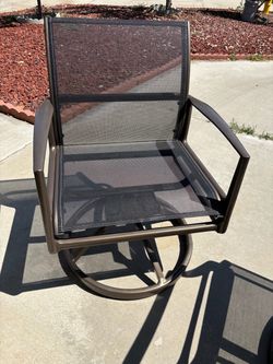 A glass-topped round table, three cast-iron swivel chairs