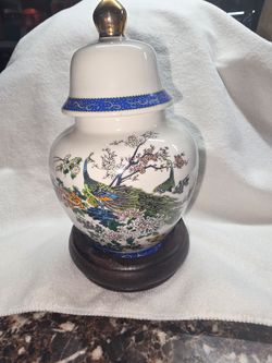 Asian porcelain ginger jar with a lid and wooden display stand
