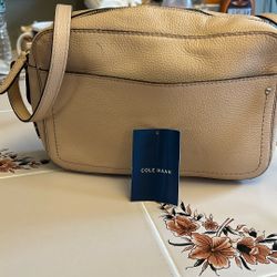 A women's beige handbag by Cole Haan in perfect condition.