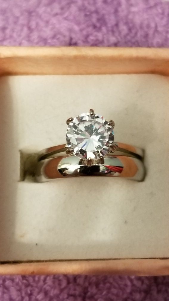 Beautiful white gold filled engagment ring with a 1.5 ct AAA cubic zirconia in it. And stainless steel wedding band . Size 7