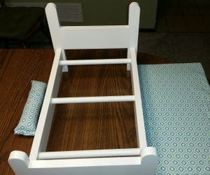 Handcrafted wooden doll bed with matching mattress and pillow.