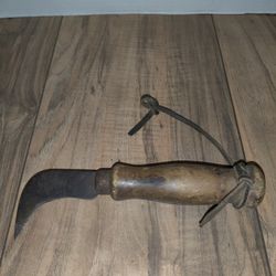 Vintage Floor Carpet Cutting Knife Wood Handle & Curved Blade. Has wear from age and use. Sold as is.

