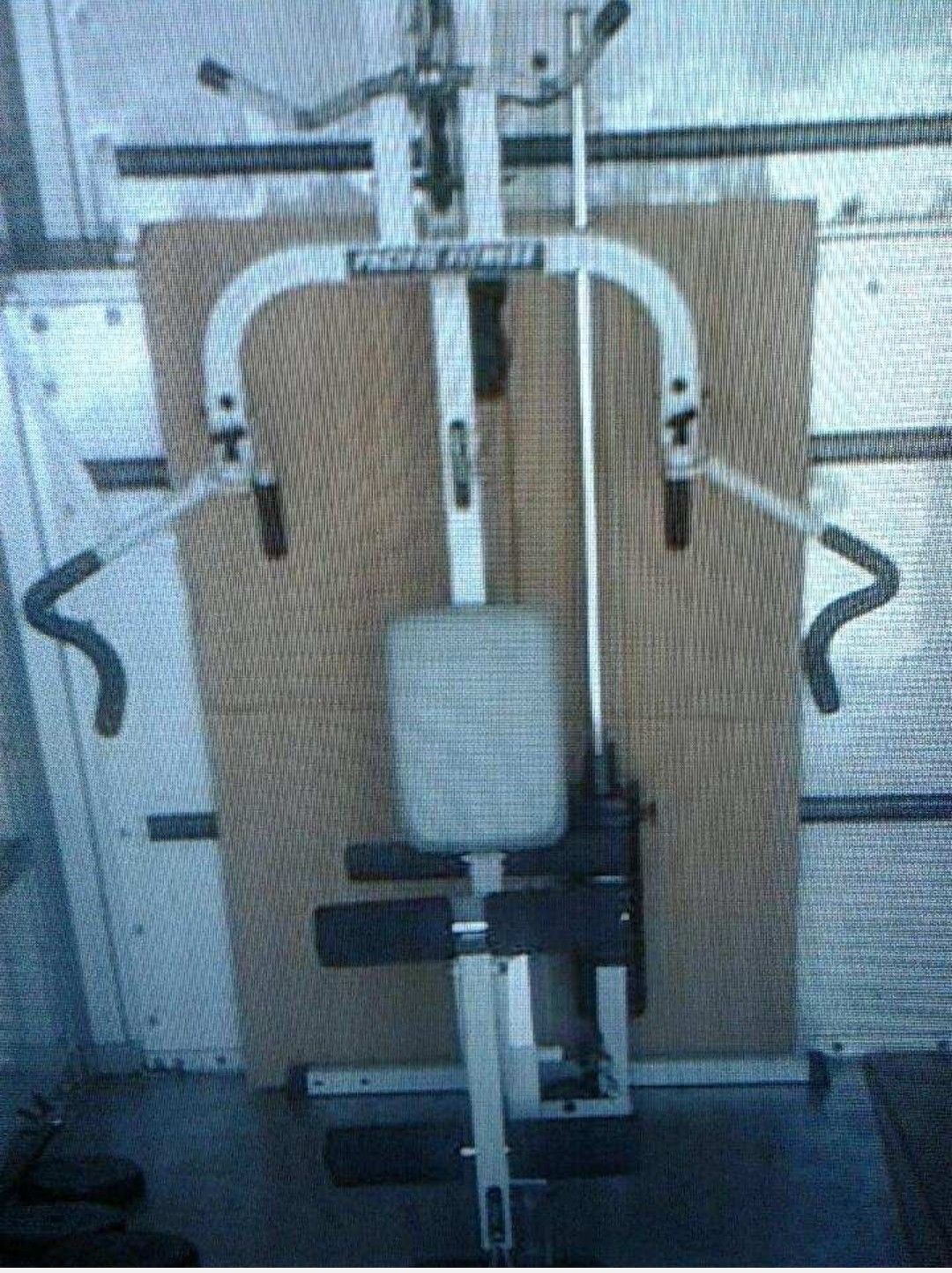 Home gym exercise machine (Pacific fitness) close a barbell and weights