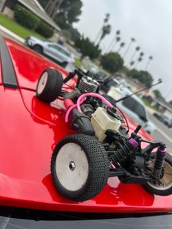 nitro-powered remote control buggy, often resembling models from brands like HPI Racing or Redcat Racing.