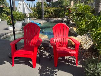 2 red resin Adirondack chairs