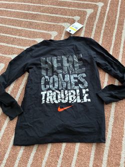 New with tag Nike kids' long-sleeve graphic tee featuring a "Here Comes Trouble" kids size S