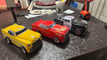 The Silver Crane Company, featuring a yellow taxi cab, a red hot rod with yellow flames, and a black-and-white police car
