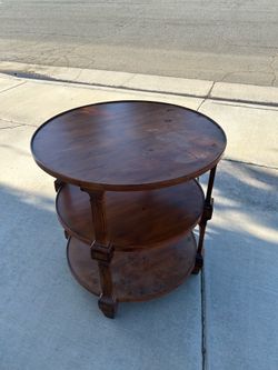 Circular wooden table with three levels.