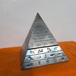 Vintage cast aluminum reproduction of an ancient Egyptian pyramid jewelry box featuring hieroglyphs.