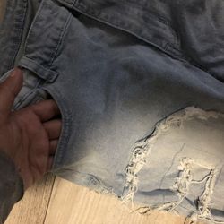 Light wash blue denim shorts with distressed details