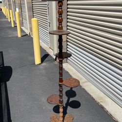 vintage tiered plant stand, likely dating from the mid-20th century. It features a central turned wooden spindle with multiple small circular platform
