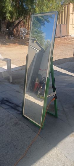 Es un espejo de cuerpo entero nuevo en su caja tiene luseses así alrededor de diferente colores