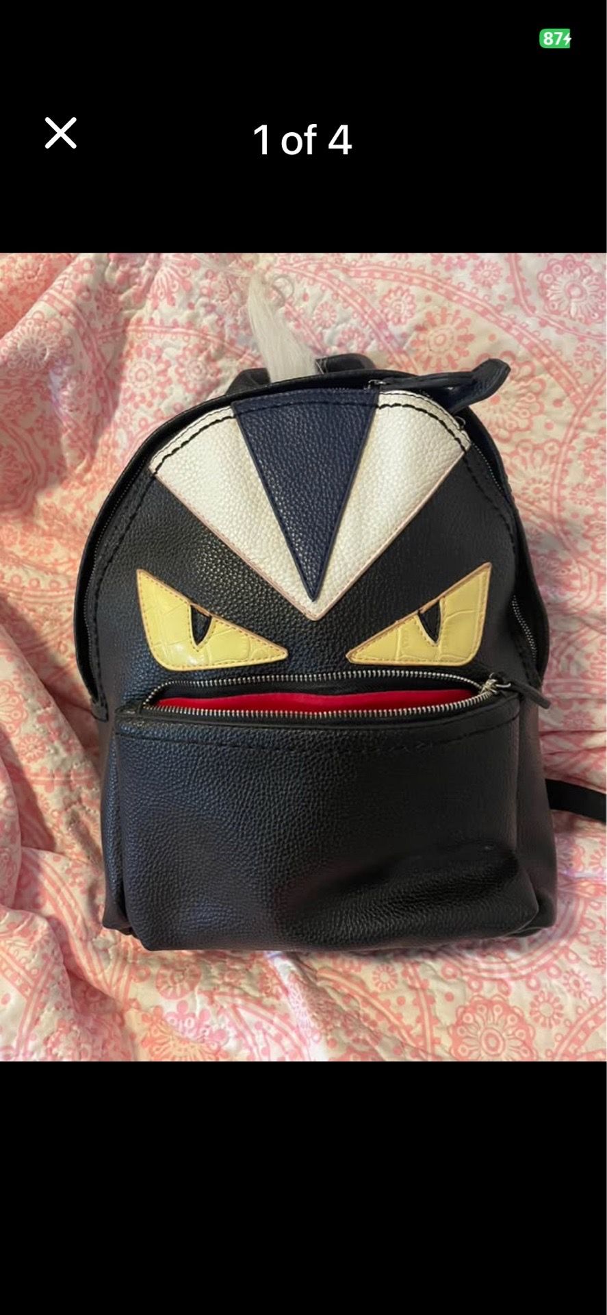 Fendi Monster backpack featuring a black leather exterior with the signature yellow and white leather monster eyes.