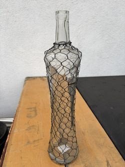 Glass bottle or decorative vase wrapped in wire mesh