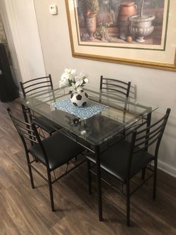 Glass dining table set with 4 black leather chairs