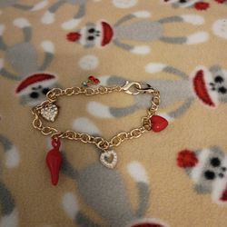 2 lobster claw bracelets with hearts cherries and jalapeno for the first one and second bracelet has a swan a four-leaf clover a heart an archangel an