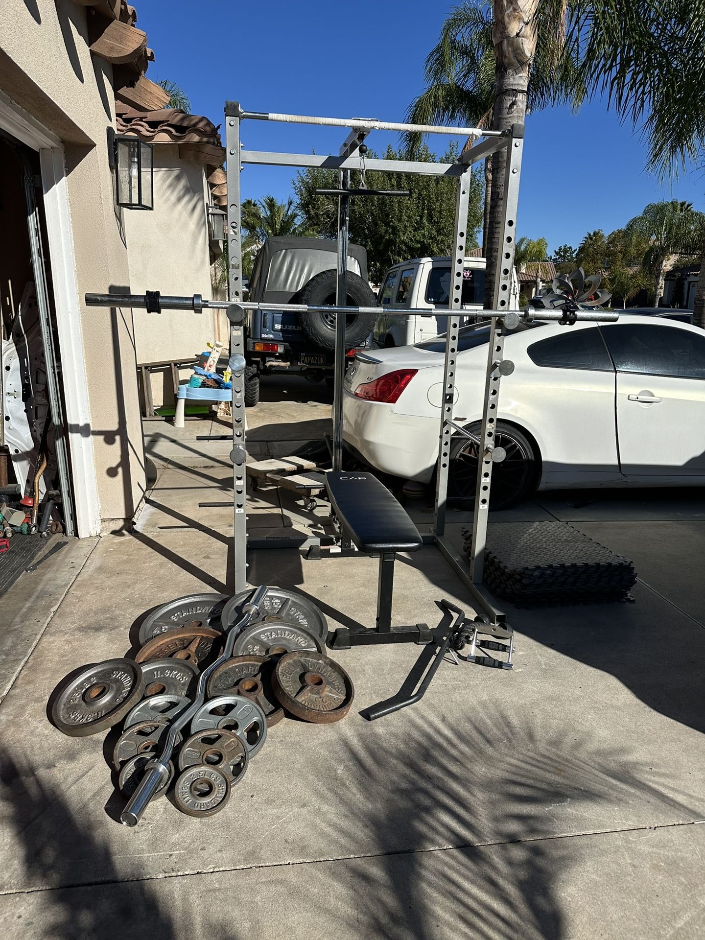 Bench press/squat rack with pulley systems and 7ft 45lbs bar plus 295lbs of Olympic weights and curl bar