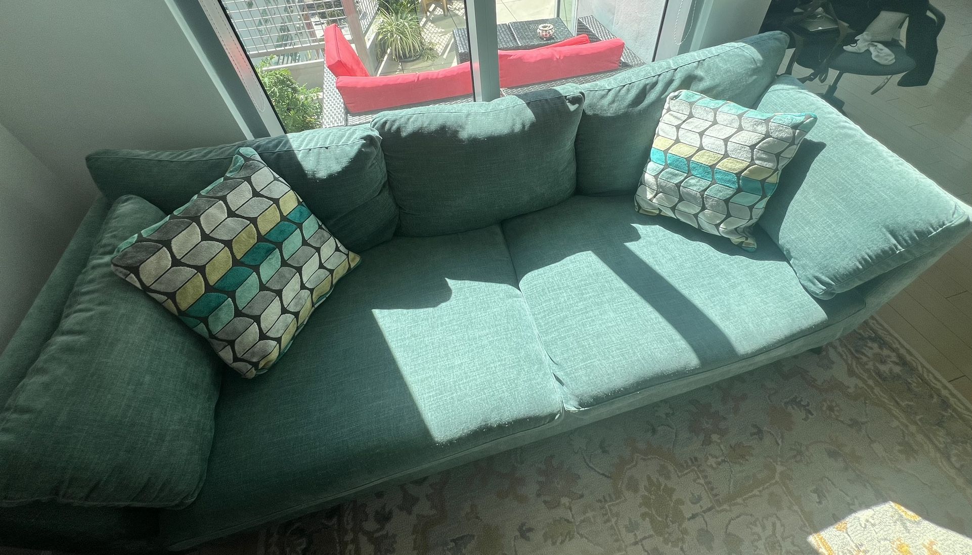 Teal Couch With Two Pillows