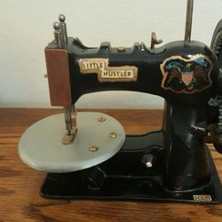 Antique mini. Little Hustler sewing machine with foot pedal wheel.