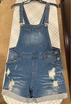 Blue denim overalls with distressed details
