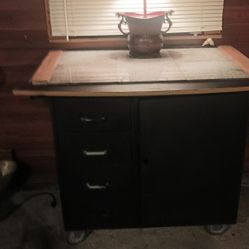 Movable  Storage And Countertop. Body Is Black With mixed white and black Marble Tiles on Countertop. 