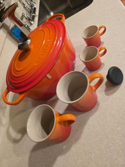 Like new set of Le Creuset big 6-3/4 quart Dutch Oven in Flame with 4 new cups and more items here