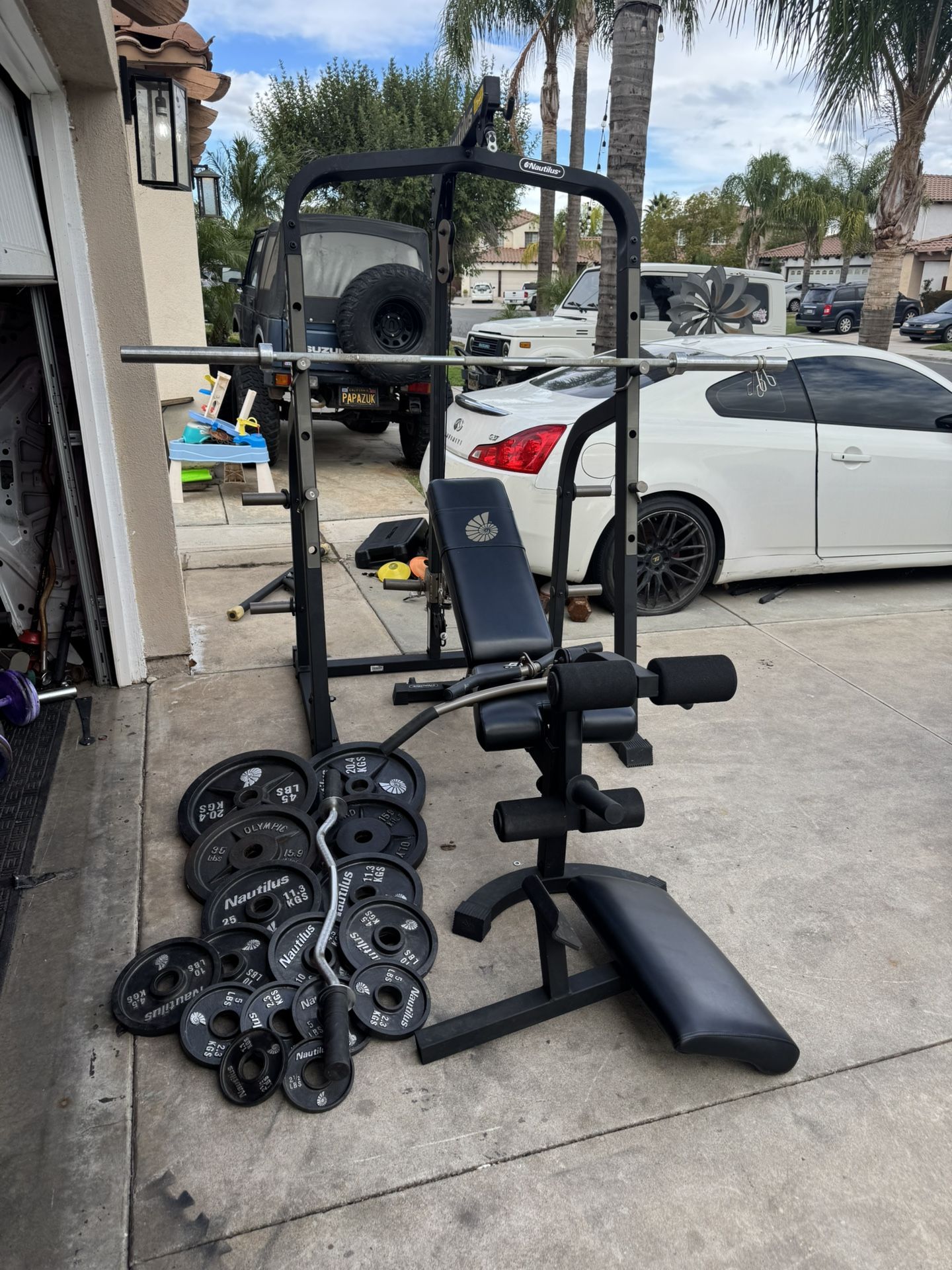Nautilus bench press/squat rack with pulley system and 275lbs of Olympic weights plus curl bar