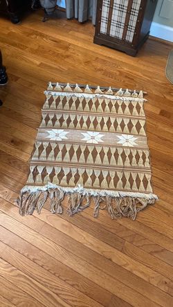 boho-style woven wall hanging featuring a geometric diamond pattern in shades of brown and beige with white star accents.