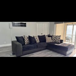 10 X 8 Black Sectional couch with a bunch of pillows