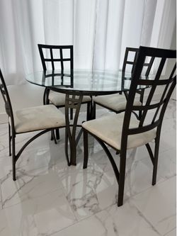 Round glass table with four chairs