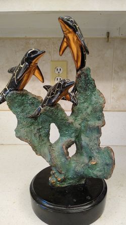 Beautiful sculpture of three dolphins.