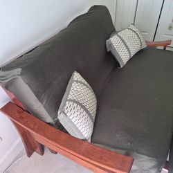 60" solid wood futon with green slip cover.