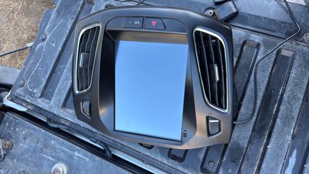 aftermarket vertical Android touchscreen head unit and integrated dash bezel designed for a 2012–2018 Ford Focus (MK3).