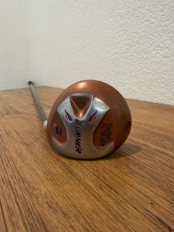 TaylorMade driver head with copper-colored crown and silver sole accents. Distinctive Burner logo and red accent details. Streamlined styling for visu