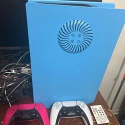 PS5 With Controllers, Cords, And Blue Faceplate That Lights Up