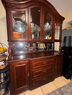 Wood china cabinet and hutch with ornate detailing, glass racks, cabinets, drawers, and lights