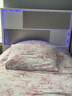 White and gray twin bed with LED lights in the headboard.