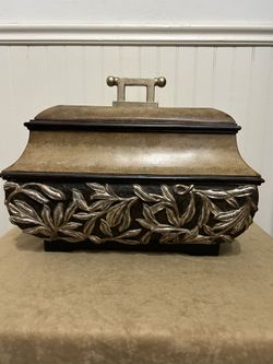 This is an vintage Ambie jewelry/storage container with a leaf-patterned design.