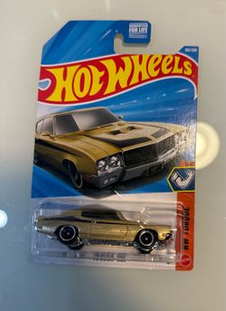 New-in-package Hot Wheels '70 Buick GSX die-cast car. This metal and plastic model has a gold body with black racing stripes and a chrome-colored base