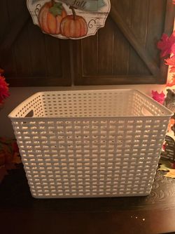 white plastic storage basket with an open woven texture and cut-out handles