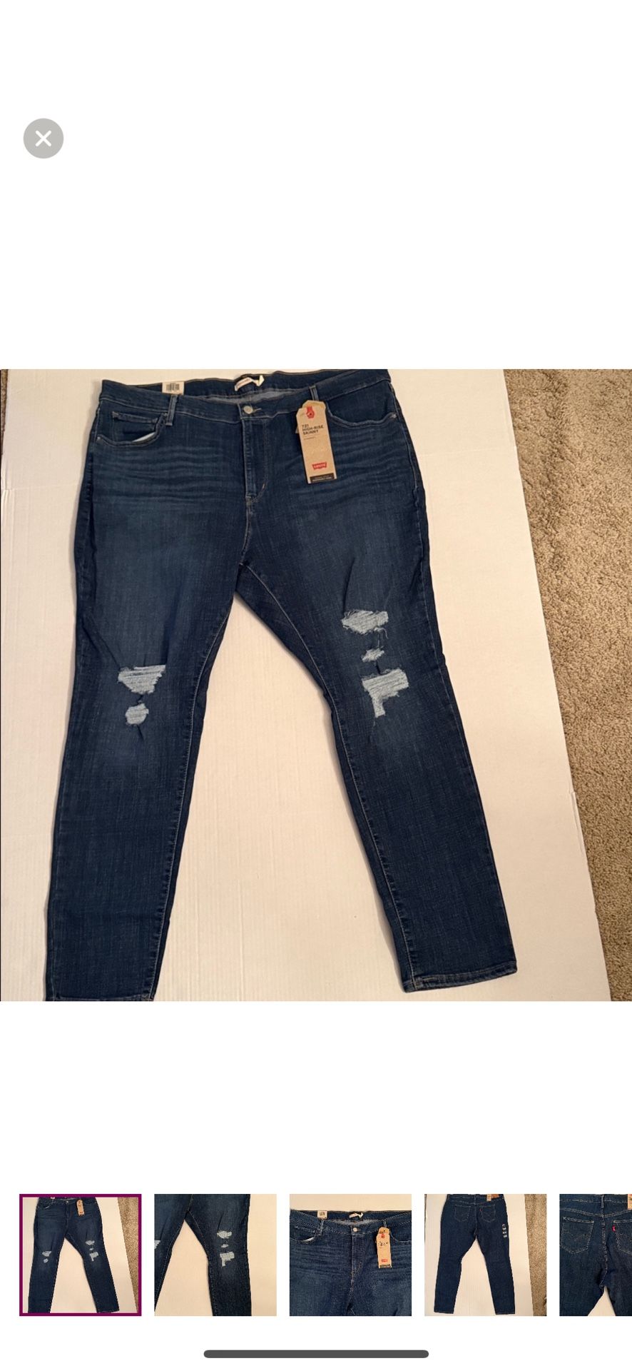 Levi's jeans with a dark blue wash. Features ripped details for a trendy look.