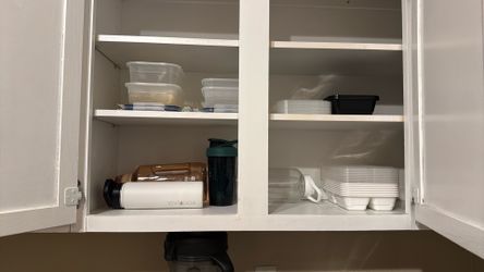 Cupboard full of bottles and meal prep containers