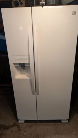 Extremely clean Kenmore side-by-side refrigerator with ice maker.