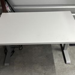 White electric height-adjustable standing desk.