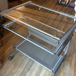 Modern style glass computer desk with a metal frame and sliding keyboard tray 