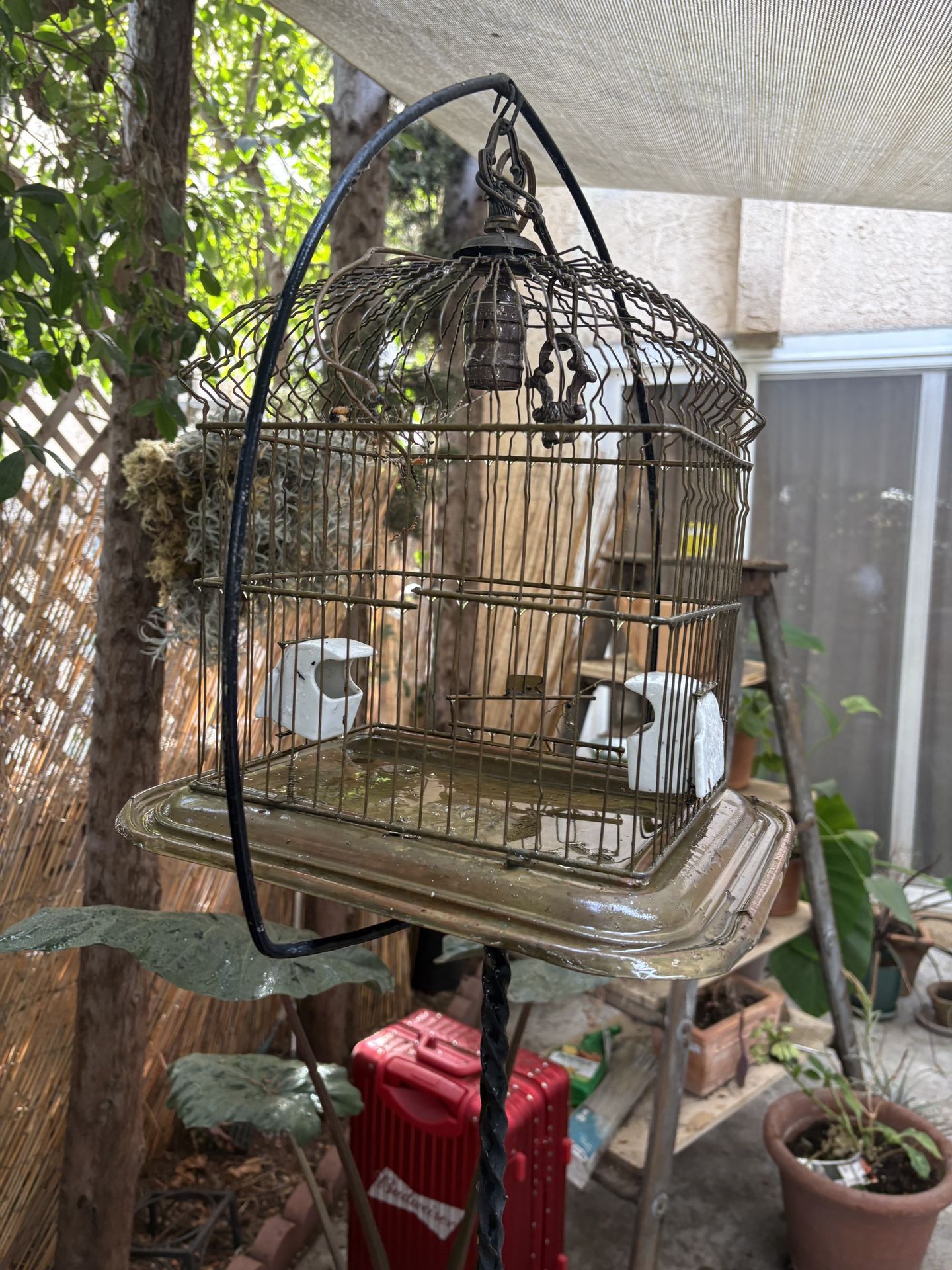 Antique Bird cage with porcelain feeders on a antique rod iron stand